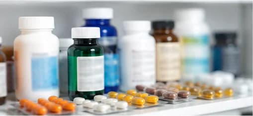Supplement bottles and blister packs on a pharmacy shelf